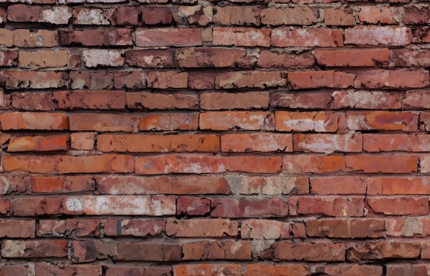 una pared de ladrillo con una mancha blanca en la parte superior.