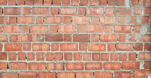 Pared de ladrillo rojo en bruto en textura de construcción para el fondo