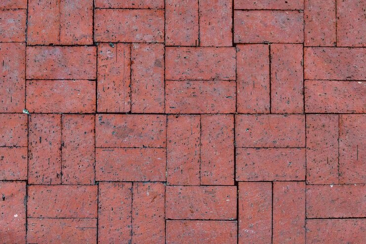 una pared de ladrillo rojo con un patrón de diferentes colores y formas