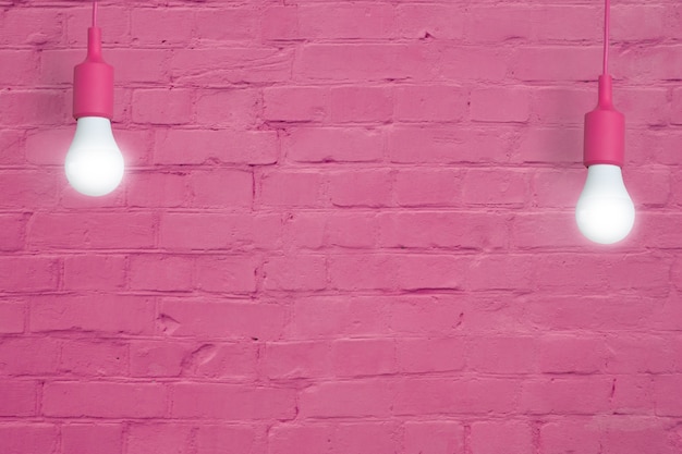 Pared de ladrillo rosa con bombillas. Copie el espacio para su texto o imagen