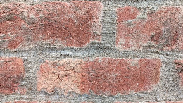 Una pared de ladrillo con una textura áspera y una textura áspera.