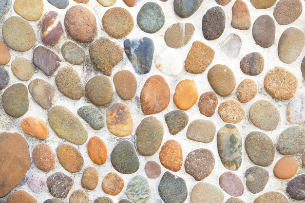 Foto pared de piedra colorida con fondo de guijarros