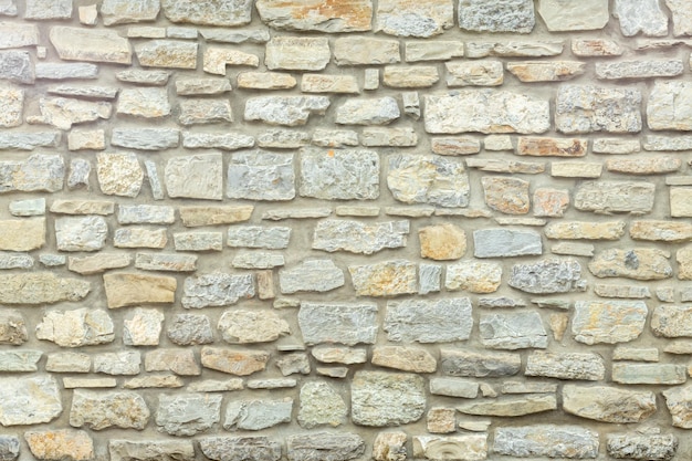 Pared de piedra sólida amarilla y beige Fondo de piedra