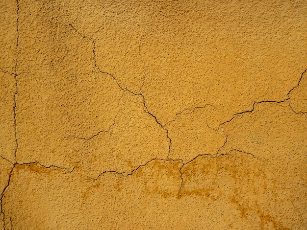 Pared pintada con pintura naranja con grietas