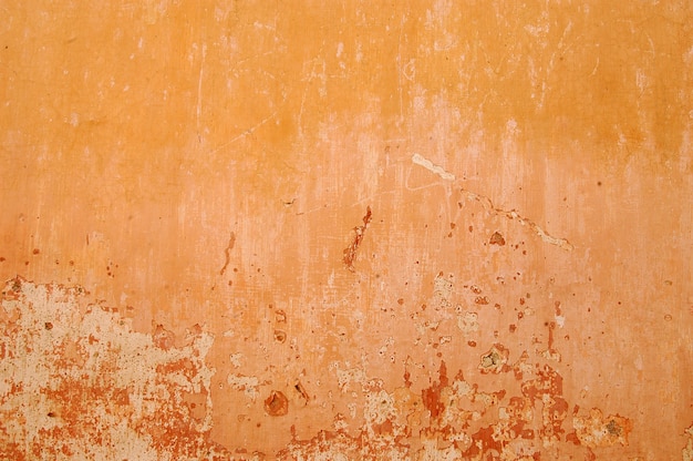 Foto pared pintada con tonos naranjas, textura de fondo agrietado, pared vieja