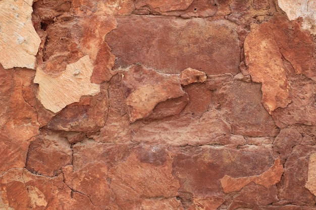 Una pared de roca roja con una textura áspera.