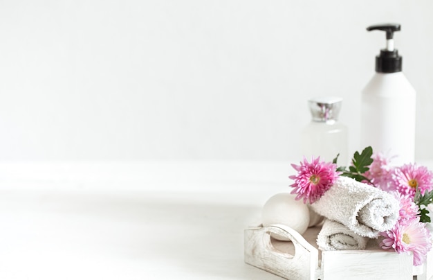 Pared de spa con productos para la higiene personal y la belleza con flores rosas. Concepto de higiene y cuidado corporal.