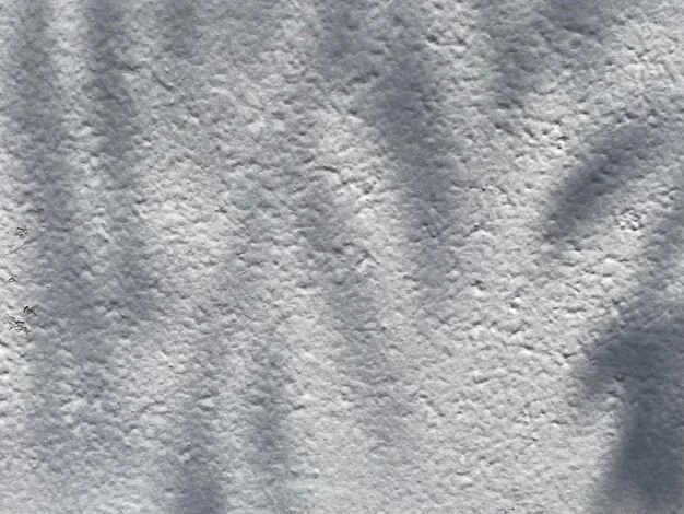 Una pared de textura blanca con un patrón de líneas y sombras.