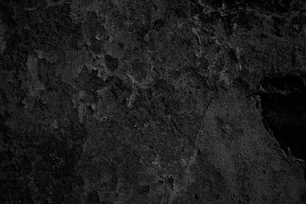 una pared de textura negra y gris con un fondo negro