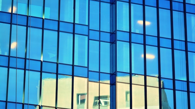 Pared de vidrio estructural que refleja el cielo azul Fragmento de arquitectura moderna abstracta
