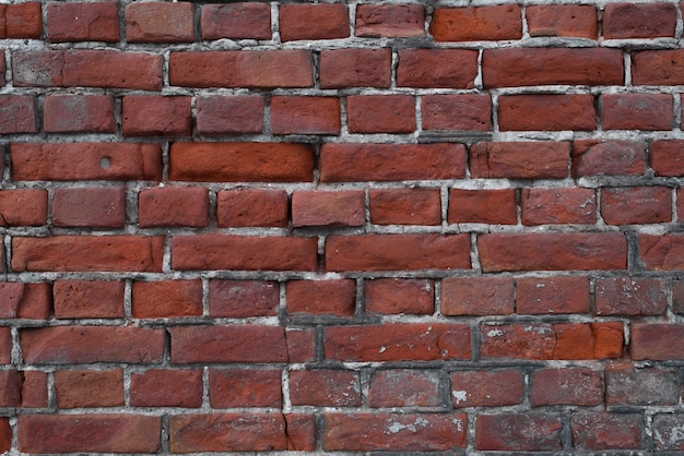 Pared vieja, rota de ladrillos rojos afuera, primer plano. Textura de fondo