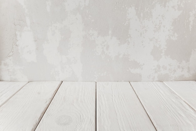 Pared de yeso antiguo con piso de madera blanca, close-up