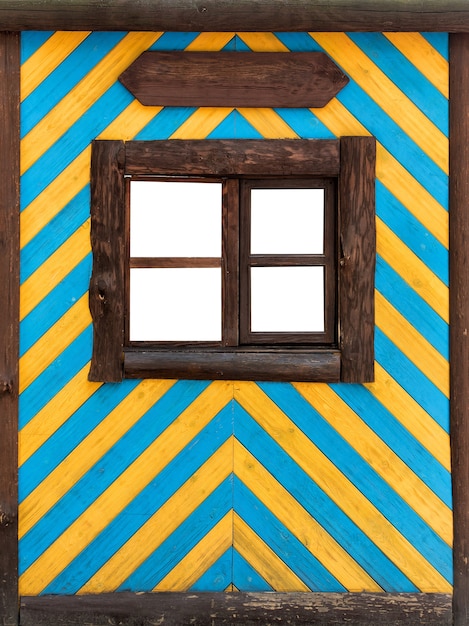 Foto parede azul-amarela com uma pequena janela de madeira. decoração de edifício antigo. quadro vertical.