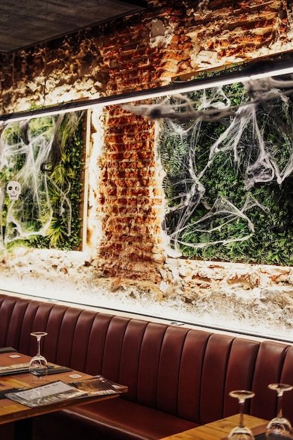 Foto parede com grama artificial e teias de aranha para o halloween.
