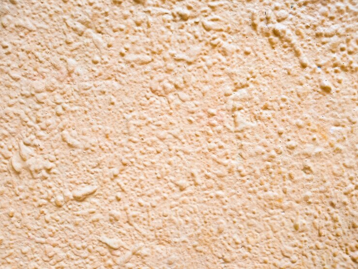 Foto parede de concreto de textura de fundo rosa abstrato. a textura rosa da superfície da parede coberta com gesso decorativo do tipo caruncho, arquitetura em close-up abstrato