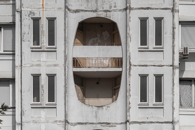 Parede de concreto em ruínas com janelas decorativas de uma casa residencial de vários andares