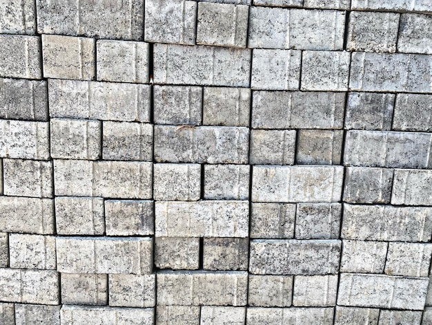 Parede de tijolo e pedra com padrão repetitivo de superfície texturizada e iluminação natural