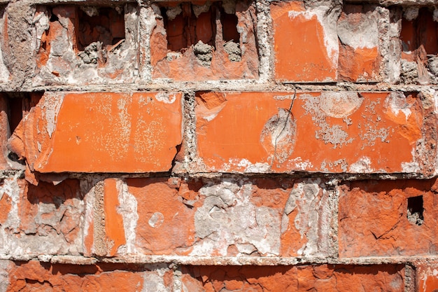 Parede de tijolo vermelho velha. Os tijolos são colocados em fileiras. Textura de pedra do grunge. Foto de alta qualidade