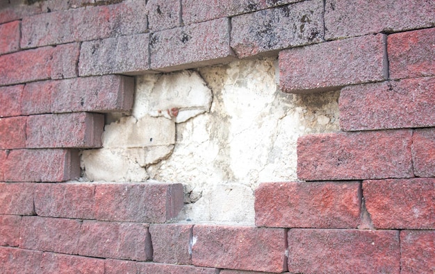 Parede de tijolos destruída Parte destruída de uma parede de tijolos e reboco Parede danificada