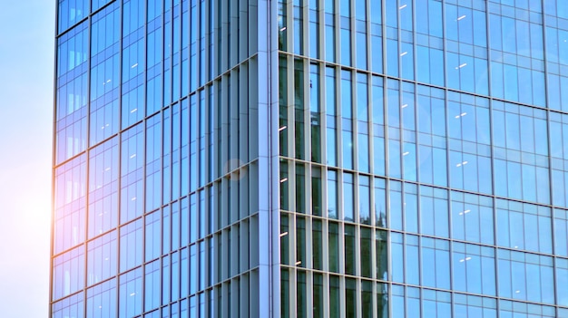 Parede de vidro estrutural refletindo o céu azul Fragmento de arquitetura moderna abstrata