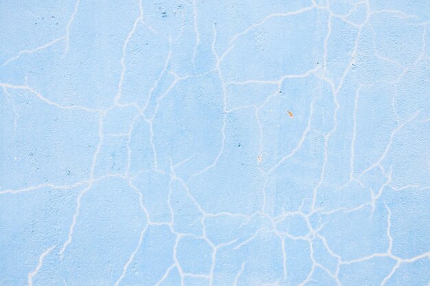 Parede rachada azul-turquesa de textura antiga, a textura de tinta antiga está lascando e destruindo a queda rachada