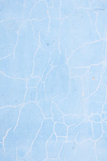 Parede rachada azul turquesa de textura antiga a textura de tinta antiga está lascando e rachando a destruição da queda formato vertical