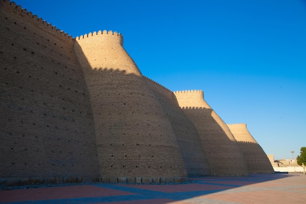 Paredes altas de tijolos sólidos da fortaleza ark em bukhara, no conceito de turismo do uzbequistão