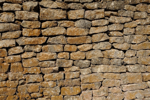 Las paredes de la casa de pila de piedra natural. cubierto de musgo seco. casa antigua. casa de albañil.