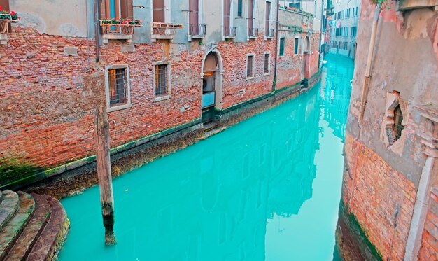 Paredes de ladrillo por un pequeño canal en Venecia Italia