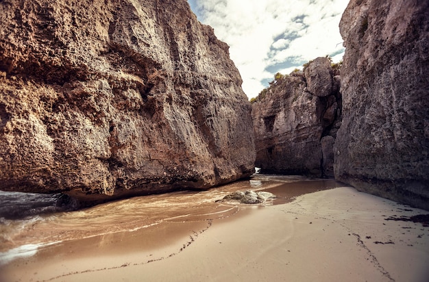 Paredes rochosas criam uma insenatira natural na praia das ruínas de tulum, no méxico