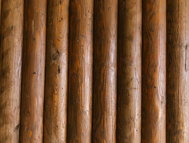 Paredes de troncos de madera de la casa Textura de troncos marrones Fondo rústico Tableros dispuestos verticalmente