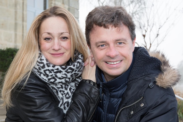 Una pareja de 40 años linda y sonriente en invierno