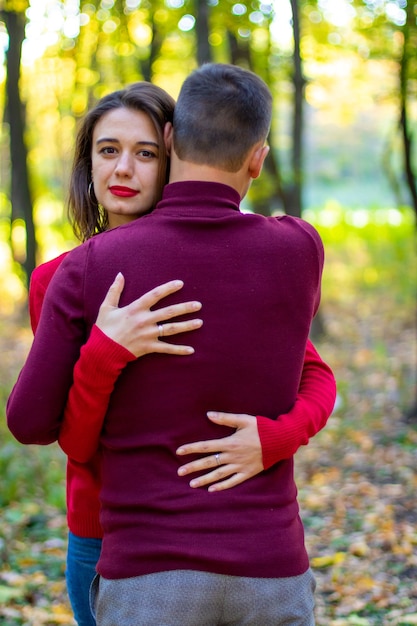 La pareja se abraza en el bosque de otoño