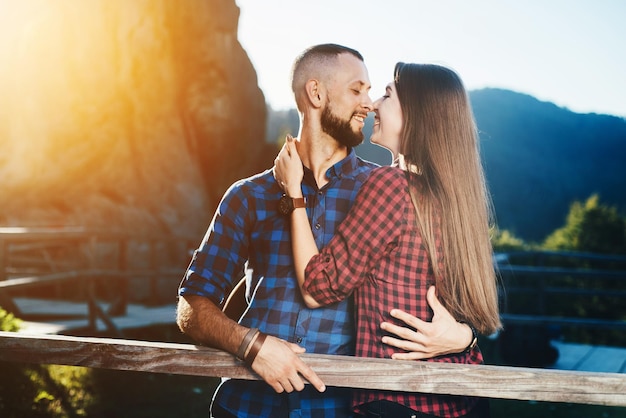 Una pareja se abraza en el fondo de las montañas.