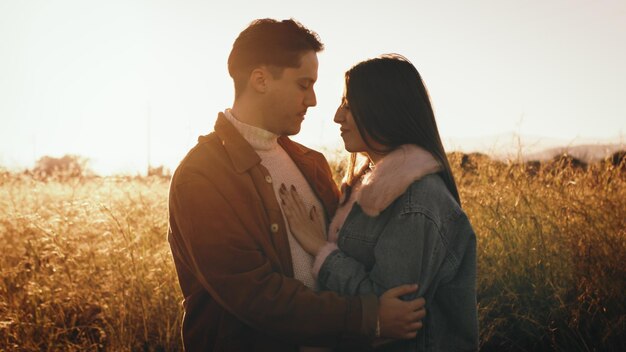 Una pareja se abraza a la luz del atardecer.