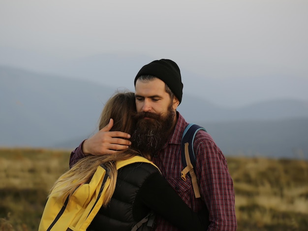 Pareja abrazada en la cima de la montaña