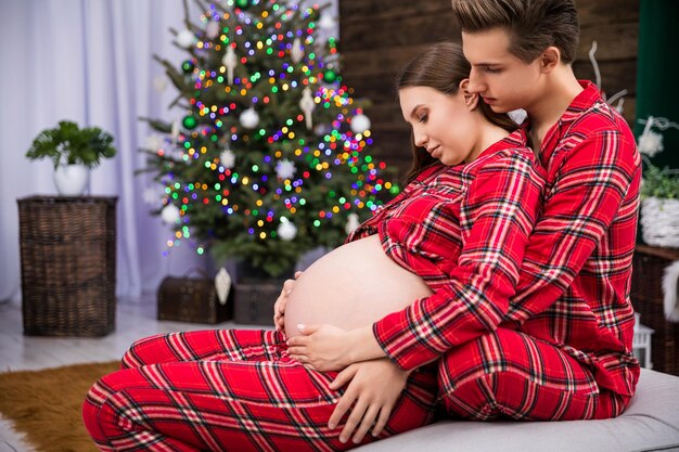 Foto pareja abrazada esperando un bebé visto de perfil