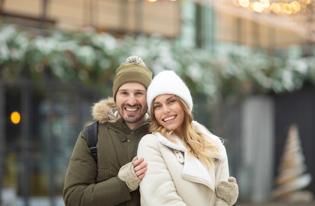 Pareja abrazada mirando a la cámara con una sonrisa en Winter Park.