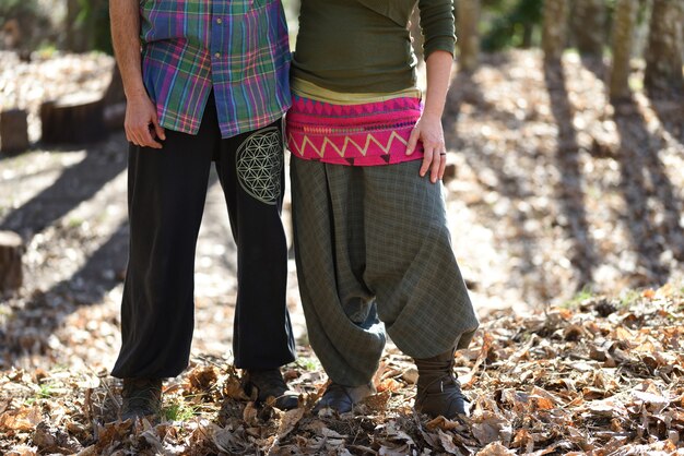 Foto pareja abrazada neo-rural en el bosque con ropa colorida.