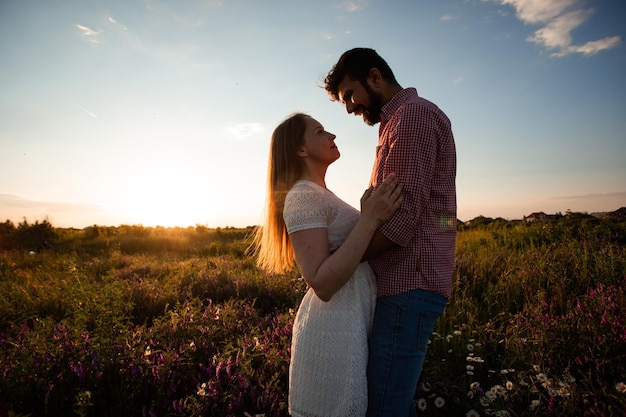 Pareja abrazada en rayos de sol poniente