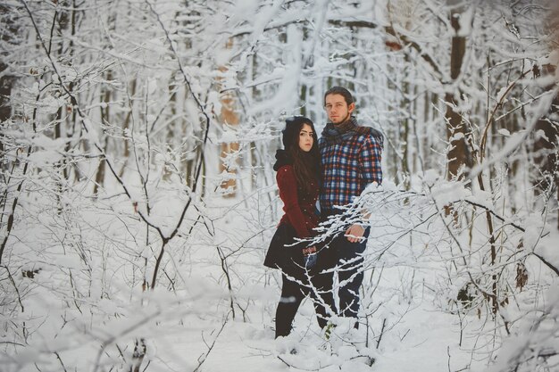 Pareja abrazándose en el bosque de invierno