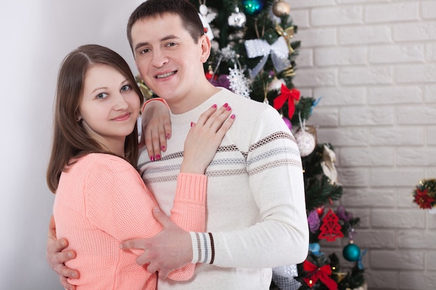 Pareja abrazándose y disfrutando de la Navidad juntos en casa