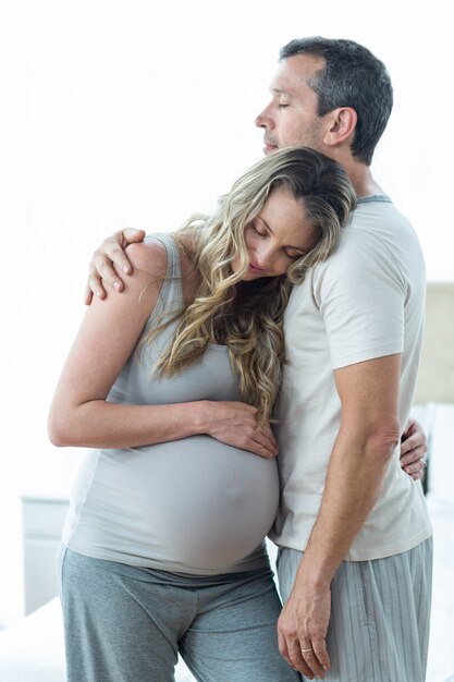 Pareja abrazándose en dormitorio