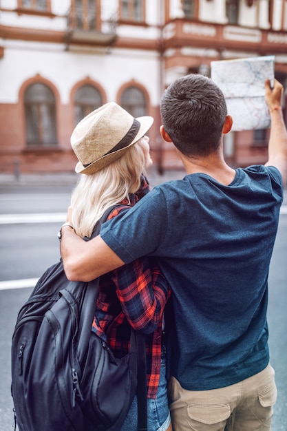 Foto pareja abrazándose con mapa en la calle