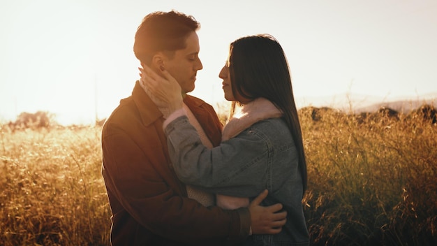 Una pareja abrazándose mientras están de pie en el campo