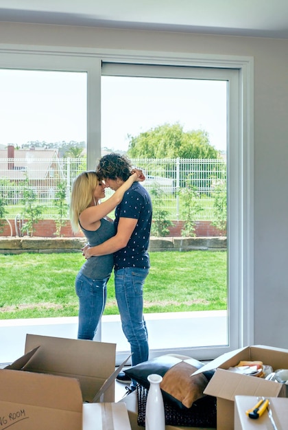 Pareja abrazándose en el salón de su nueva casa