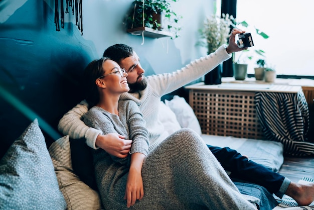 pareja, abrazar, en, sofá, y, toma, autorretrato, en casa