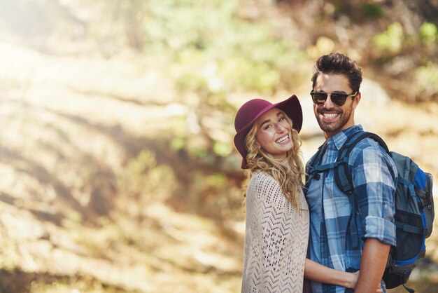 pareja abrazo y retrato al aire libre para hacer senderismo en la naturaleza en vacaciones juntos y caminar en el bosque para la aventura hombre mujer y sonreír en el bosque por explorar en vacaciones de viaje en Nueva Zelanda con el espacio