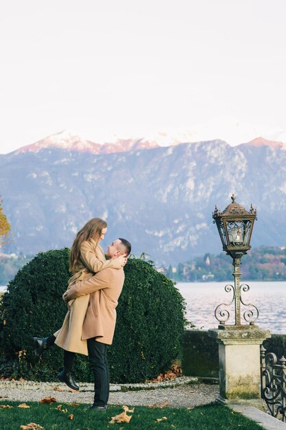 Pareja con abrigo marrón cerca del lago de Como