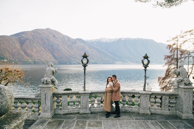 Pareja con abrigo marrón cerca del lago de Como